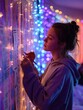 © Anat art - Young Woman Creating Artistic Wall Collage With Colorful Lights in Cozy Indoor Setting During Evening Hours