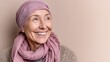 © ryanbagoez - Middle-aged woman cancer patient wearing headscarf and smiling on pink background.