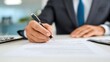 © MuhammadHajiji - Business Professional Signing Important Documents in Modern Office
