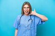 © luismolinero - Young surgeon doctor woman isolated on blue background making phone gesture. Call me back sign