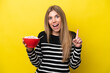 © luismolinero - Young caucasian woman holding a bowl of cereals isolated on yellow background intending to realizes the solution while lifting a finger up