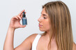 © luismolinero - Young caucasian woman isolated on white background holding a serum. Close up portrait