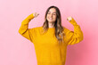 © luismolinero - Young Romanian woman isolated on pink background doing strong gesture