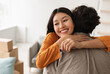 © Prostock-studio - Smiling young Asian woman hugging her boyfriend and holding house key on moving day, free space. Loving millennial couple embracing in their new home during relocation