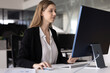 © fizkes - Positive focused 20s corporate professional girl working at computer, using monitor and mouse at workplace table, using business financial application on pc for job task