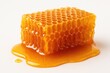 © vxnaghiyev - Detailed view of a honeycomb segment filled with honey against a white backdrop