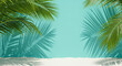 © PhotoArtHub - Teal background with palm leaves and shadows cast on white sand below, showcasing a summery beach scene ideal for product display or advertisement