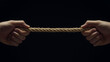 © HADI INCREDIBLE - Two hands pulling a thick brown rope in a tug-of-war against a black background.