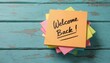 © Lubov - Colorful post-it notes with handwritten text Welcome Back. Conveying greeting, motivation, organization at work or school. Positive message, cheerful announcement in office. Concept return.