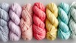 © Jojo* - A close-up view of colorful yarn balls, displayed in a spectrum of pastel shades, including pinks, lavenders, yellows, and mint greens, creating a vibrant and inspiring display.