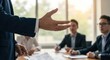 © Art - Business meeting with a person gesturing in front of colleagues at a table.