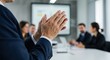 © Art - Business meeting scene with hands clapping in foreground and people blurred.