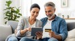 © MDARIF - Couple shopping online with tablet and credit card at home, enjoying the convenience of ecommerce and digital payments in their living room