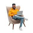 © Ramdan - Smiling african american man working with laptop in armchair against black background