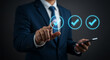 © StarMind_Ahsan - A businessman is using a smartphone to select a check mark icon, representing success, approval, and verification in a business or quality control context
