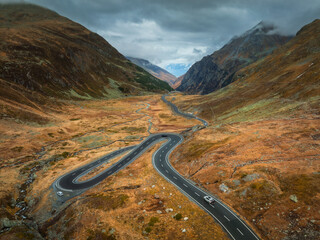 Wall Mural - aerial view of winding road in high alpine valley in the swiss alps, switzerland in autumn. top dron