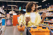 © anatoliycherkas - Woman choosing between white and brown rice in supermarket