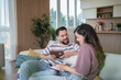 © Migma_Agency - Happy couple watching old photo albums and remembering memories at home