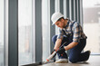 © Serhii - Construction worker sealing window frame with silicone gun in modern building