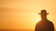 © Pica Be - Silhouette of a cowboy against a vibrant sunset sky