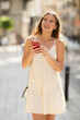 © JackF - Happy young woman with mobile phone in her hands walking around the city and taking pictures of sights