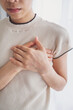 © Ton Photographer4289 - A woman places her hand on her chest, experiencing chest pain from a heart attack. Healthcare and medical concept.