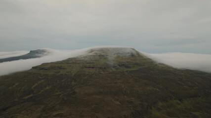 Wall Mural - aerial drone shot of the scottish coastline after sunset, with dramatic clouds rolling over the land