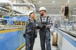 © Serhii - Engineers walking and discussing production with laptop in factory