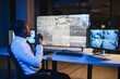 © Serhii - African American security officer or dispatch uses computer and walkie talkie, looks at screens