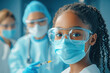 © Chatchaa - A young girl in protective gear smiles at the camera, surrounded by medical professionals wearing masks and gloves in a healthcare setting.