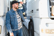 © Serhii - Confident male driver standing in front on his truck