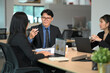 © Prathankarnpap - Professional colleagues discussing project details in a modern office