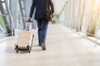 © Anastasiya - African American businessman in suit walking through airport terminal with rolling luggage. Concept of travel, business trip, mobility and global transportation