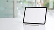 © Dini Wahyuni - Blank digital tablet screen on a modern white desk with a stylus, ideal for design, business, or educational content display in a professional setting.
