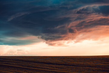 Wall Mural - Spectacular ominous clouds before the storm glowing in the sun's rays in rural area.