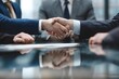 © YiXiong - Businesspeople shaking hands at a conference table.