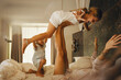 © Jacob Lund - Family enjoying morning in hotel bed, kids playing and having fun on vacation
