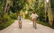 © Jacob Lund - Happy family biking on a lush tropical island during vacation