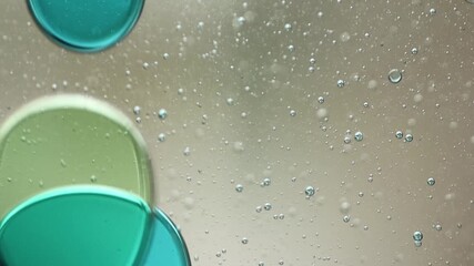 Wall Mural - Close-up of blue and green liquid with floating bubbles and blobs in motion inside a lava lamp, viewed in a horizontal orientation. Hypnotic and abstract visual texture.