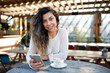 © Austockphoto - Young middle eastern woman enjoying time on phone at cafe