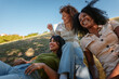 © bernardbodo - Three young women enjoying a relaxing picnic in the park