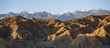 © Mara Brandl/imageBROKER - Landscape of eroded hills at sunrise, badlands, white mountain peaks of the Tian Shan Mountains in the background, Canyon of the Forgotten Rivers, Issyk Kul, Kyrgyzstan