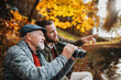 © Halfpoint - Senior father and his son with binoculars in nature, talking.