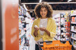 © anatoliycherkas - Woman choosing deodorant in supermarket aisle pushing shopping cart