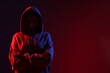 © New Africa - Anonymity. Woman hiding her face on dark red background, space for text