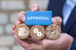 © wladimir1804 - Business person holding wooden blocks with icons sees the word APPROVAL. Approval Efficiency Policy Progress Business Concept. Approved document or agreement.