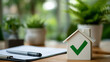 © Maksym - Illustration: wooden house model with green tick, modern office desk setting, pen and papers in soft-focus, symbolizing approval of mortgage and home purchase