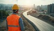 © miss irine - Civil engineer in hard hat and safety vest surveys a highway construction project during daytime. Aerial view shows urban development, infrastructure planning, and heavy equipment progress.