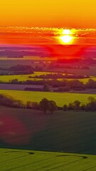 Wall Mural - vibrant sunset sky over fields in moving time-lapse view, tranquil scenery