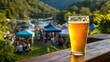 © mila103 - A glass of beer is sitting on a wooden table in front of a crowd of people. The atmosphere is lively and social, with people enjoying the outdoors and each other's company